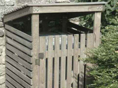 A spruce wheelie bin cover in a garden